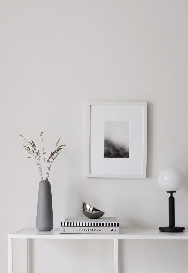 a white table with vases and pictures on it