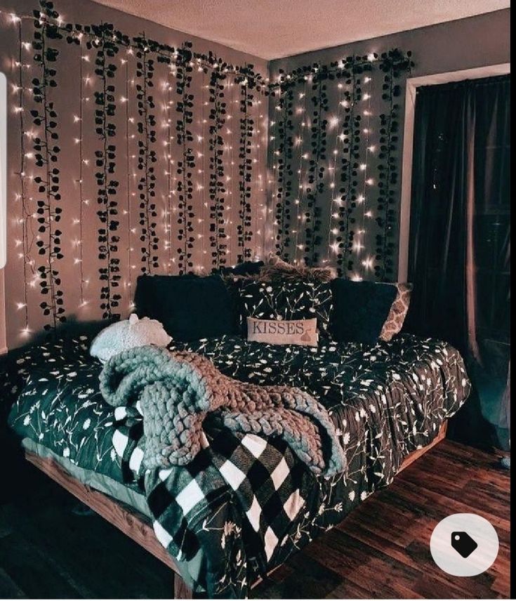 a bedroom decorated in black and white with string lights on the wall behind the bed