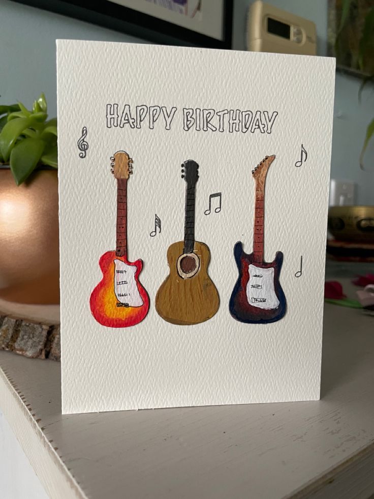 a card with three guitars and the words happy birthday