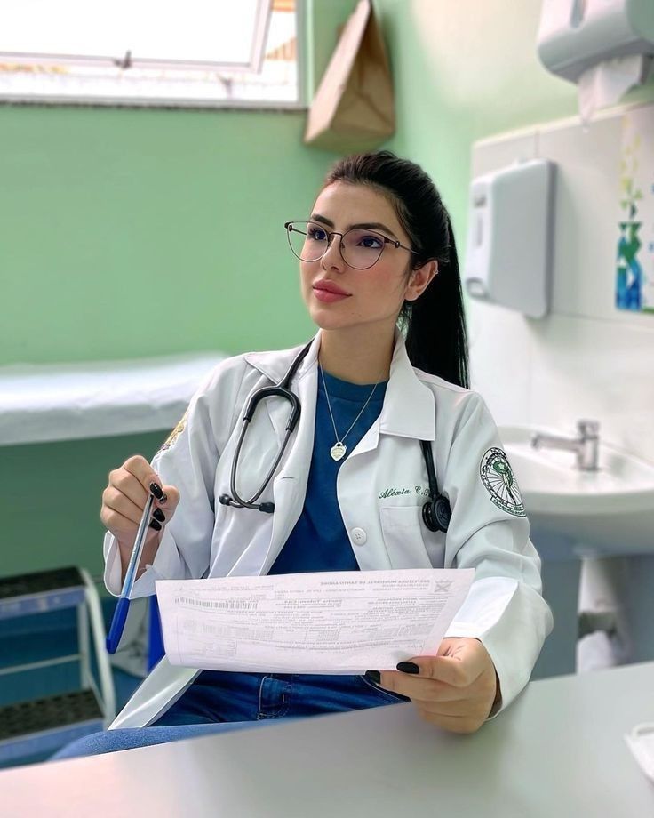 a female doctor sitting at a desk holding a piece of paper