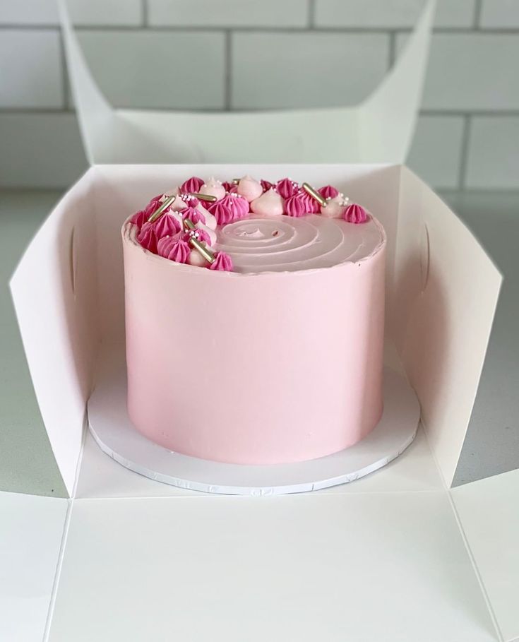 a pink cake in a white box on a table