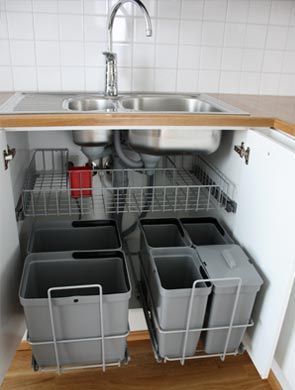 the kitchen sink is open and has several containers in it, which are stacked on top of each other