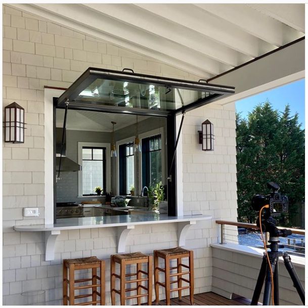 an outdoor bar with three stools and a camera