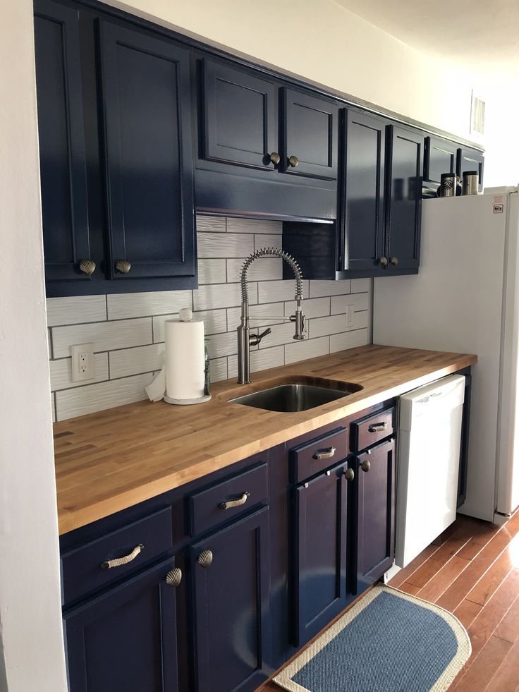 a kitchen with blue cabinets and wooden counter tops