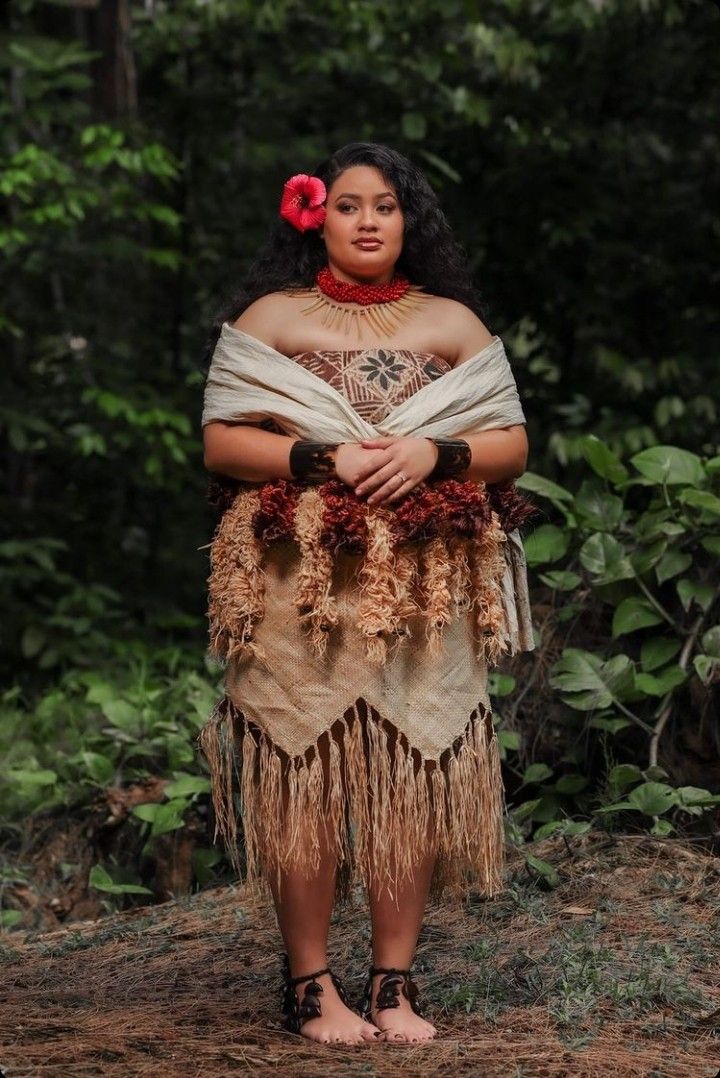 a woman dressed in native garb standing with her arms crossed