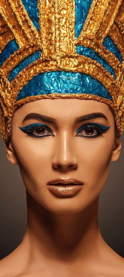 an image of a woman wearing a gold and blue headdress on her face