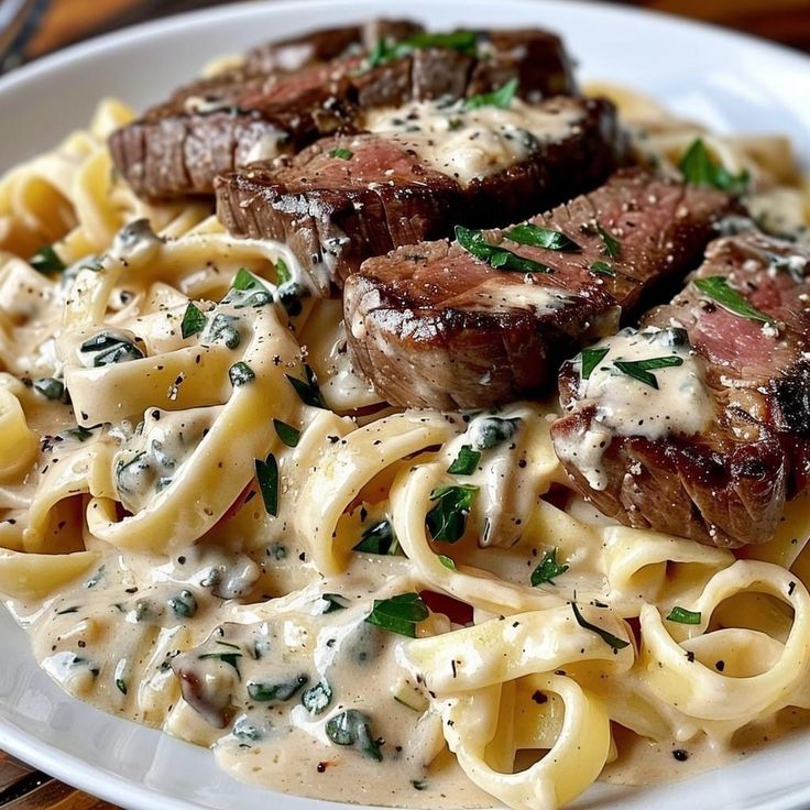 some meat and noodles on a white plate