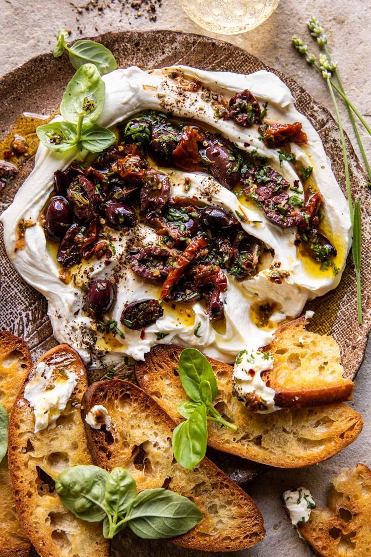 a plate with bread, cheese and herbs on it