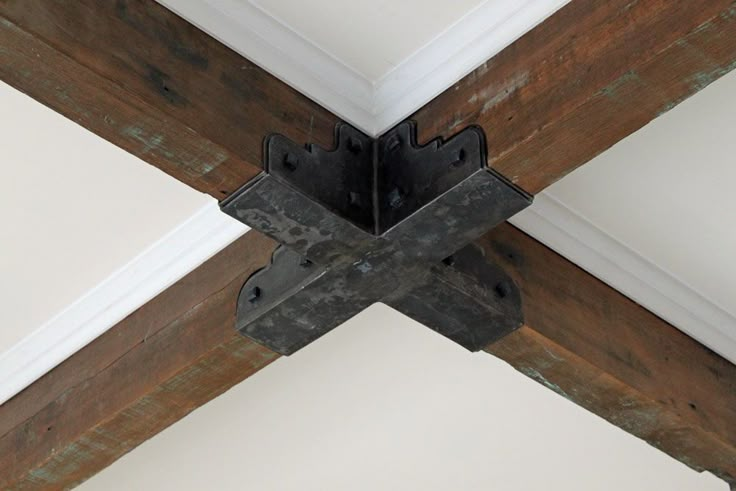 an old wooden beam is attached to the ceiling with metal brackets on it's sides