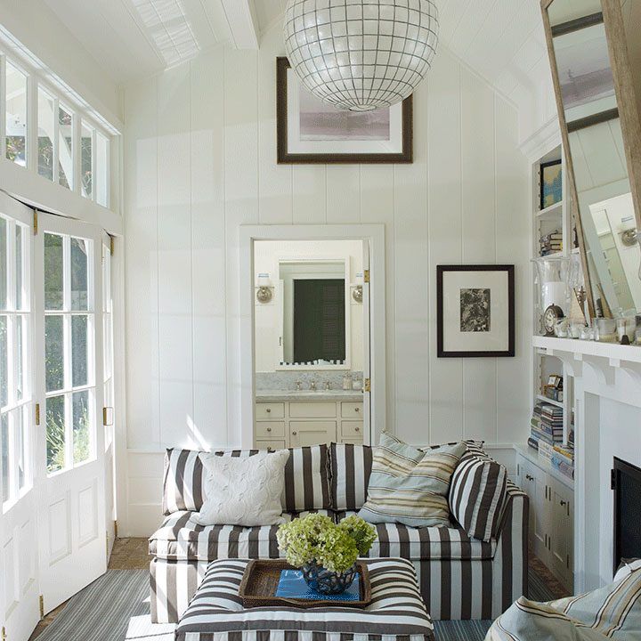 a living room filled with furniture and a fire place under a light hanging from the ceiling