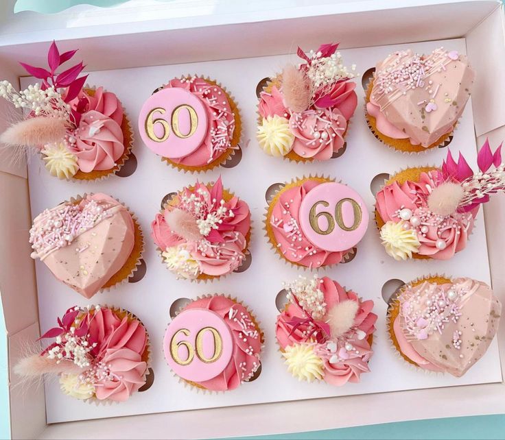 pink and white cupcakes in a box with number 60 on the top one