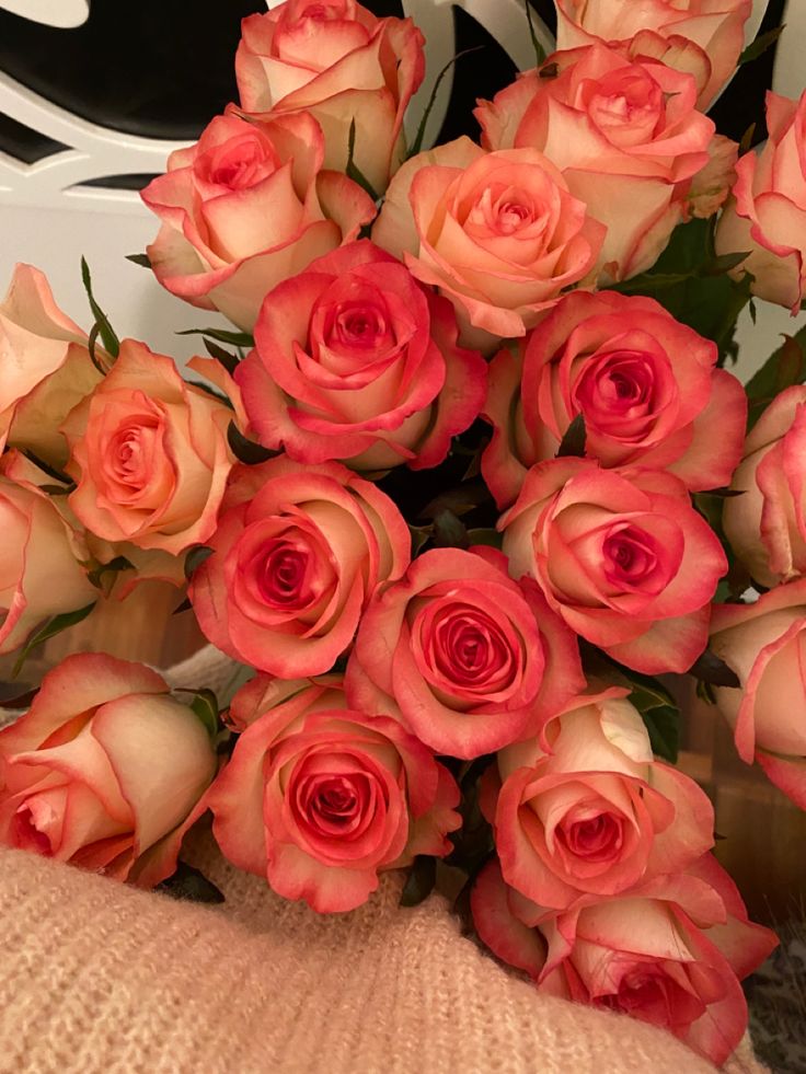 a bouquet of pink roses sitting on top of a table