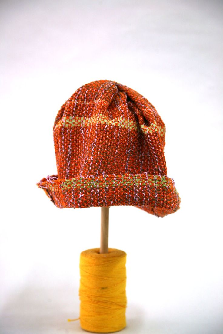 "A cheerful way to get through winter!  This lightweight one of a kind hat can be worn year round.  It is handwoven with a variety of fibers. The main body is orange, but it contains yellow, greens, browns, lilacs and metallic yarns.  One size fits many.  It measures 27 cm from top to brim, with a 4 cm (1.5 inch) brim, it has a circumference of 63.5 cm at the brim.  Hand wash.  Please note - colors may vary from photo. Allow for slight variations in color as their appearance may differ from scre Orange Wide Brim Hat For Winter, Orange Wide Brim Winter Hat, Orange Brimmed Hat For Fall, Artisan Brown Handwoven Hat, Artisan Handwoven Brown Hat, Spring Brown Knitted Hats, Brown Handwoven Crochet Hat With Short Brim, Orange Short Brim Hat, One Size Fits Most, Orange Short Brim Hat, One Size