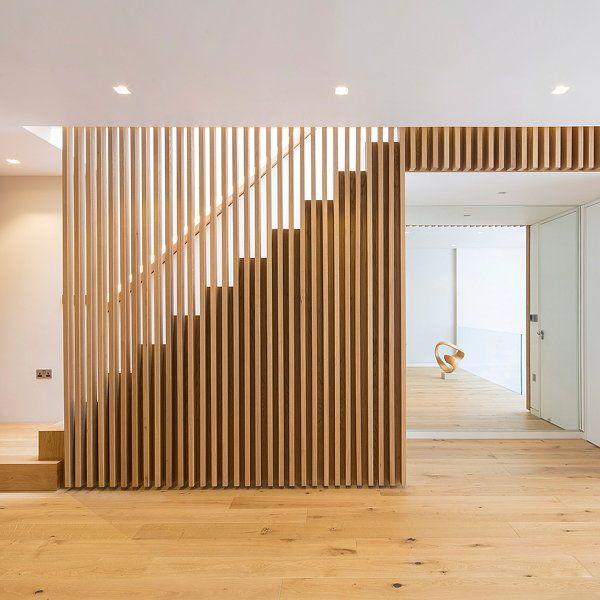 an empty room with wood slats on the wall and wooden stairs leading up to it