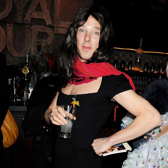 a woman standing in front of a bar holding a drink