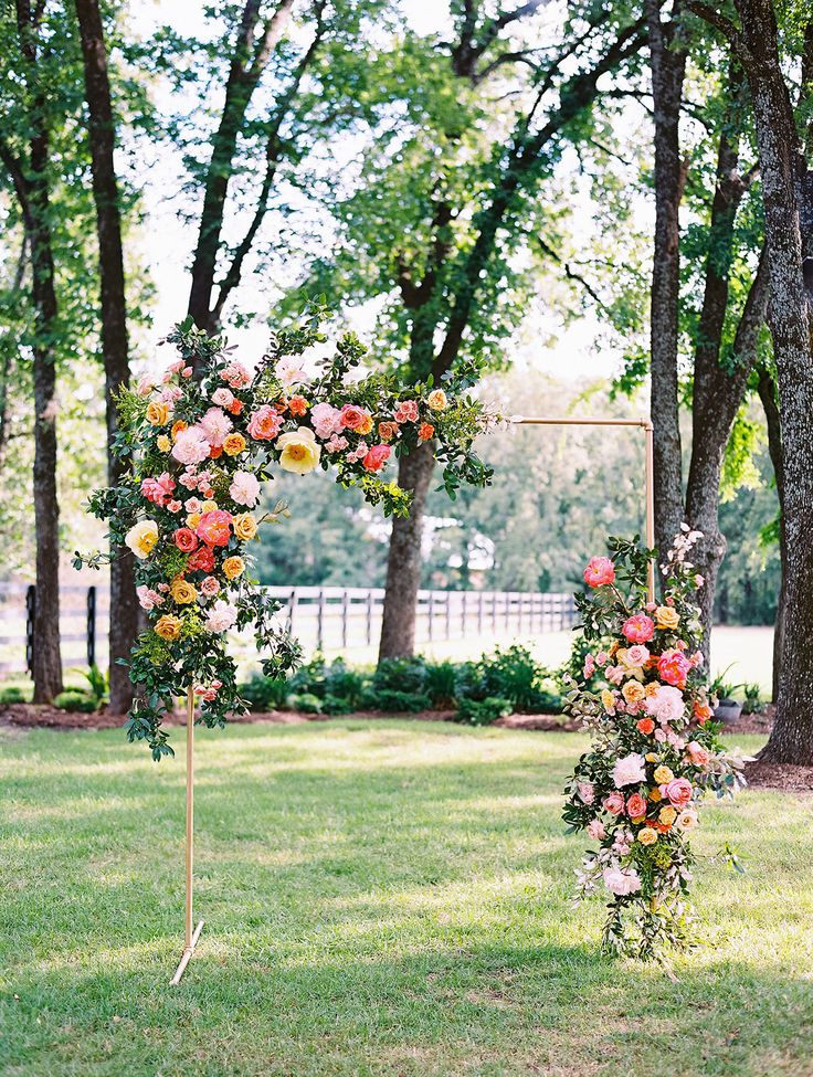 an outdoor wedding ceremony setup with floral arch