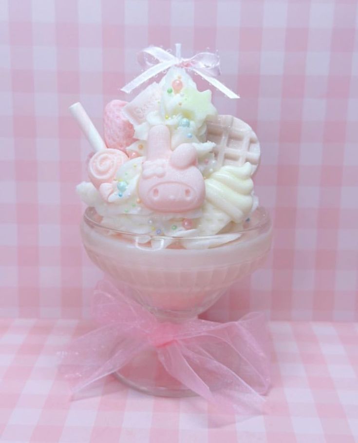 a pink bowl filled with lots of different types of candies and marshmallows