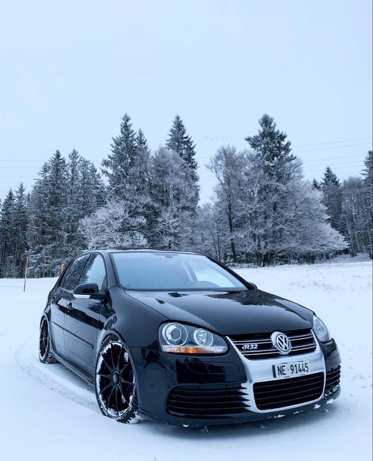 a black car is parked in the snow