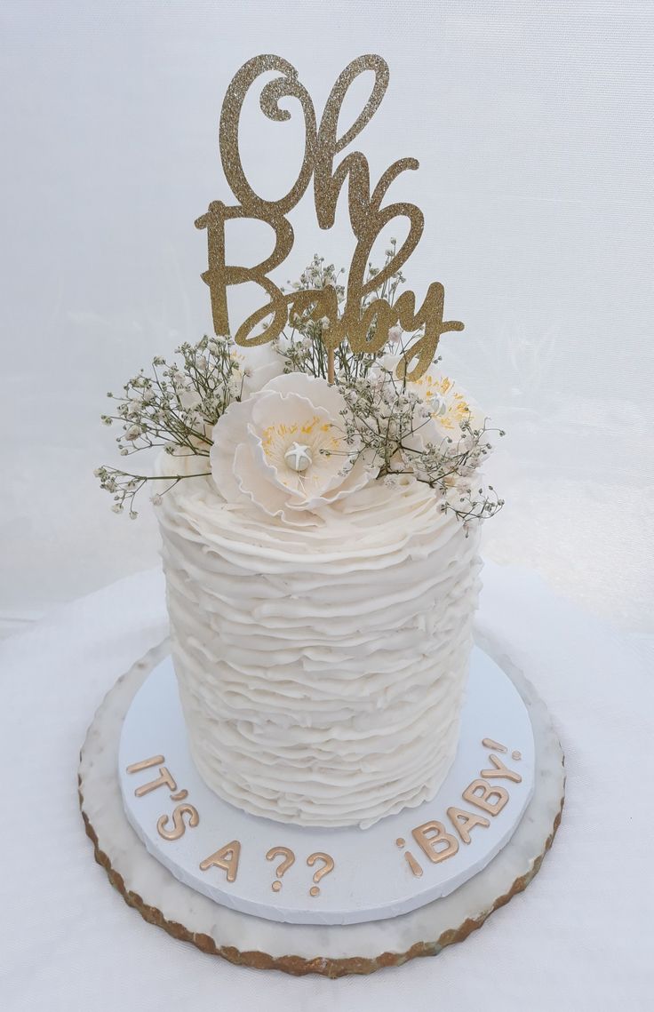 a white cake with gold letters and flowers on top