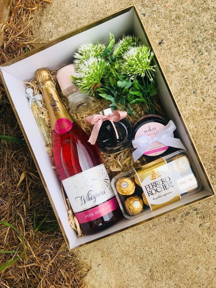 an open box with wine, champagne and flowers