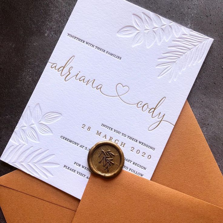 an orange envelope with a wax stamp on it and a wedding card in the middle