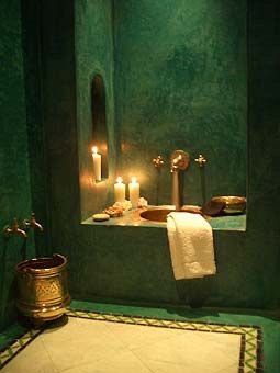 a bathroom with green walls and candles on the counter