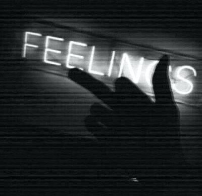 a person holding their hand up in front of a neon sign that reads feelin's