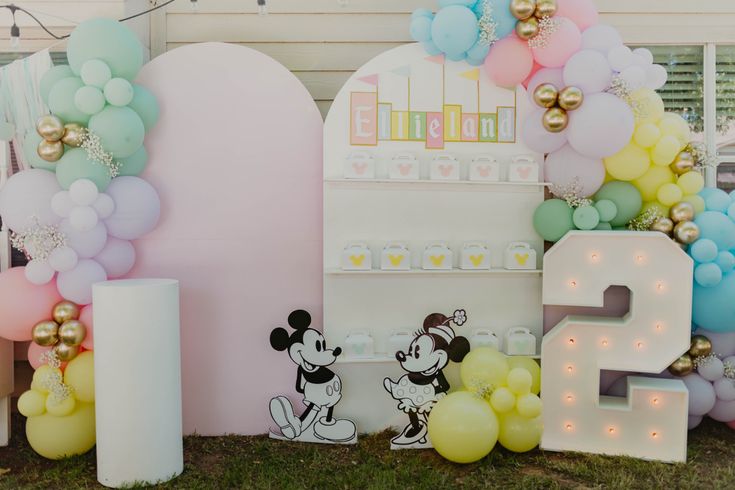 a mickey mouse themed birthday party with balloons