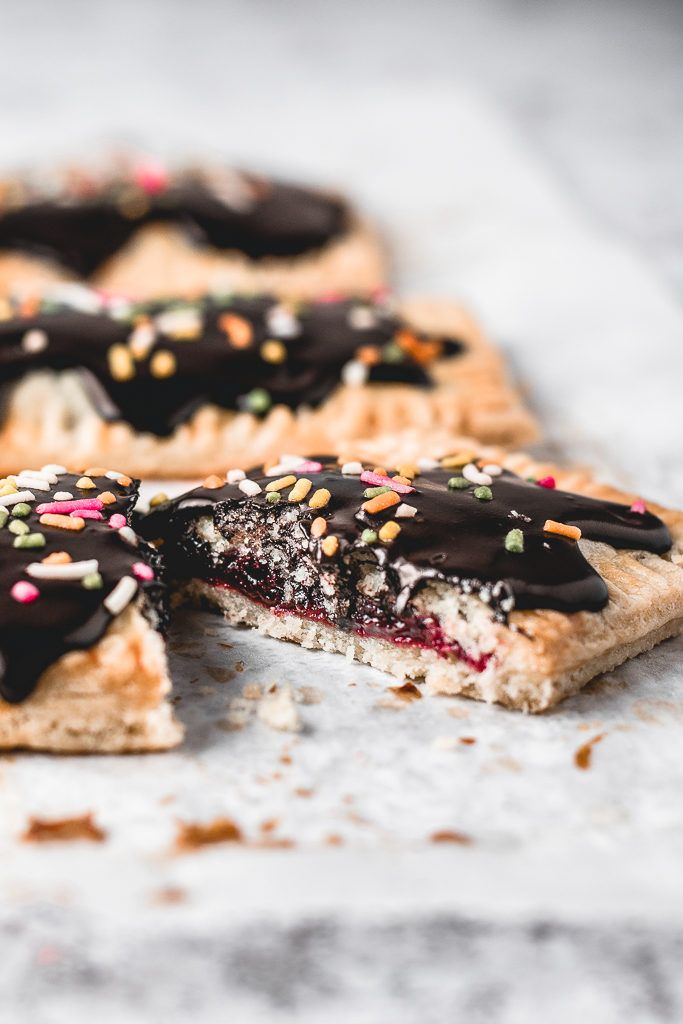 chocolate covered pastry with sprinkles cut in half on top of a table