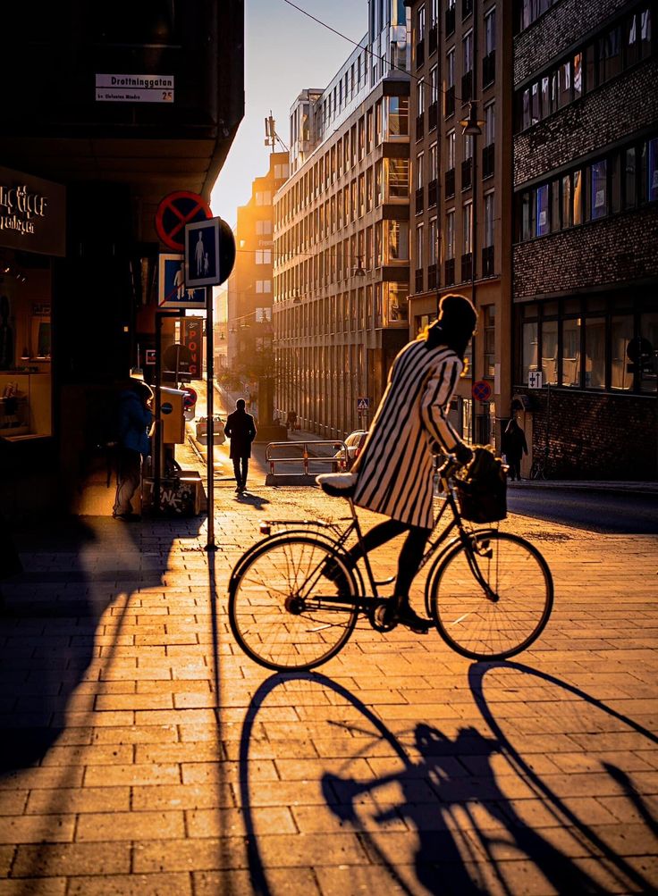 a man riding a bike down a street next to tall buildings