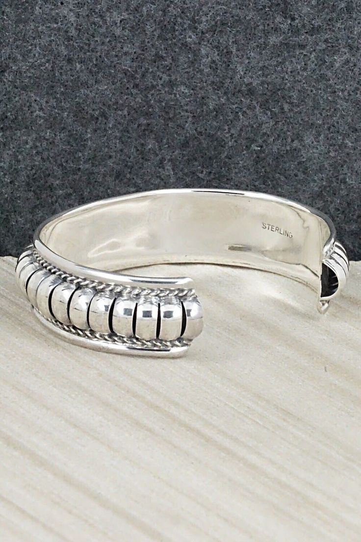 This sterling silver bracelet was made by Navajo silversmith Manuel Johnson. The inside is signed MJ and stamped sterling.Size: 5 5/8" (will fit up to a 6 7/8" wrist)Gap: 1 1/4"Width: 5/8"Free shipping on all orders! We ship with USPS and always include tracking. All orders ship within a day of payment.Returns are accepted up to 30 days after you receive your order. Just send us a message. Our shop offers cash back or store credit. The item must be returned in new condition. Nickel-free Southwestern Sterling Silver Bracelet, Sterling Silver Bracelet, Sterling Silver Bracelets, Silver Bracelet, Gap, Stamp, Bracelet, Sterling Silver, Free Shipping