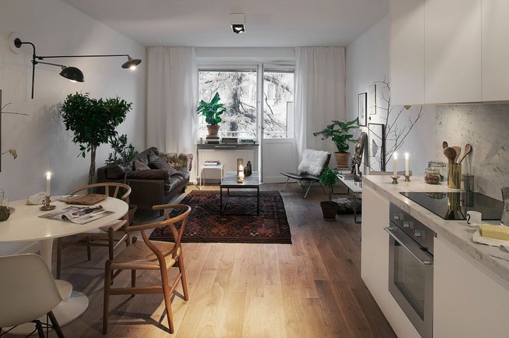 a living room filled with furniture next to a kitchen and dining room table in front of a window