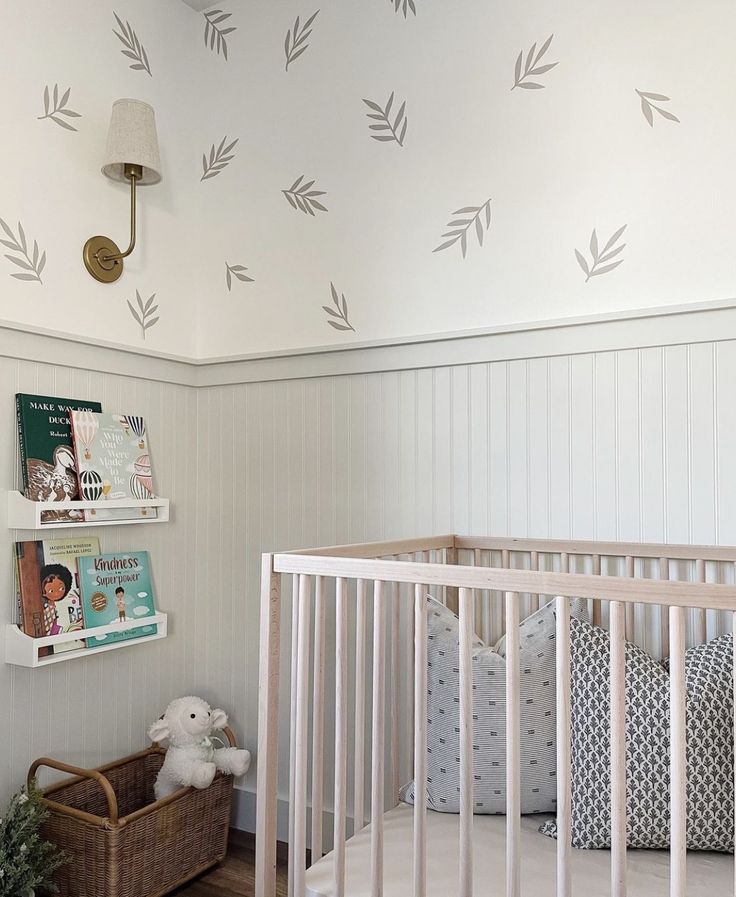 a baby's room decorated in white and gray with arrows on the wall above the crib