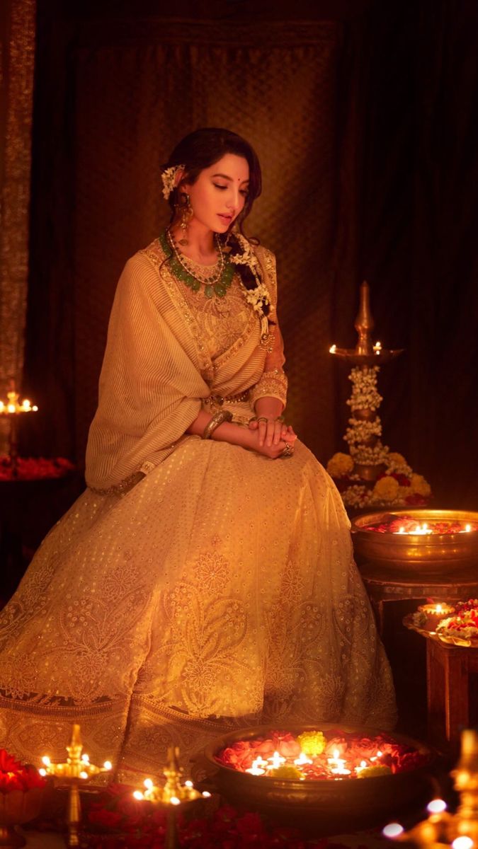 a woman in a yellow dress sitting on a table surrounded by candles and other decorations