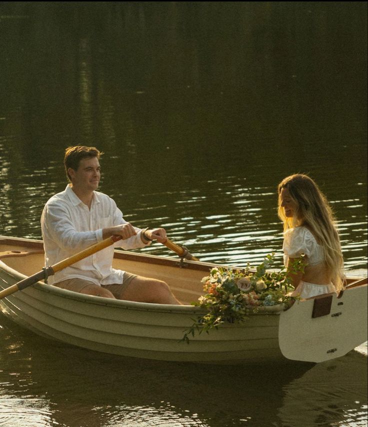 a man and woman in a row boat on the water