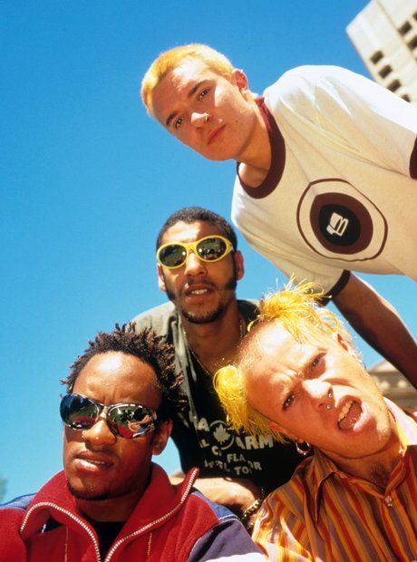 three men are posing for the camera with one man wearing sunglasses and the other smiling