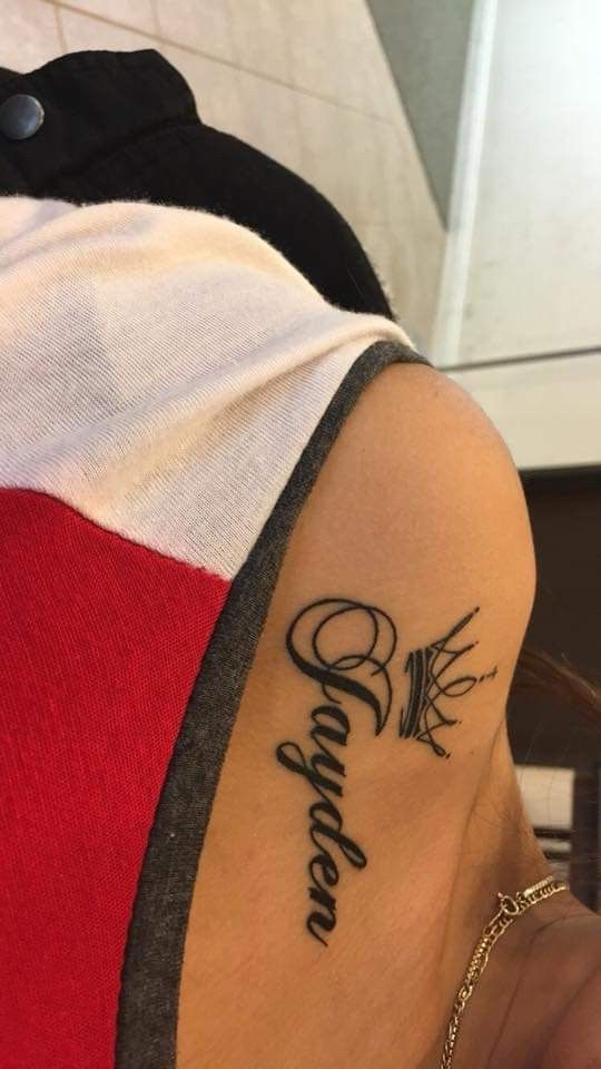 a woman with a tattoo on her arm and the word believe written in cursive writing