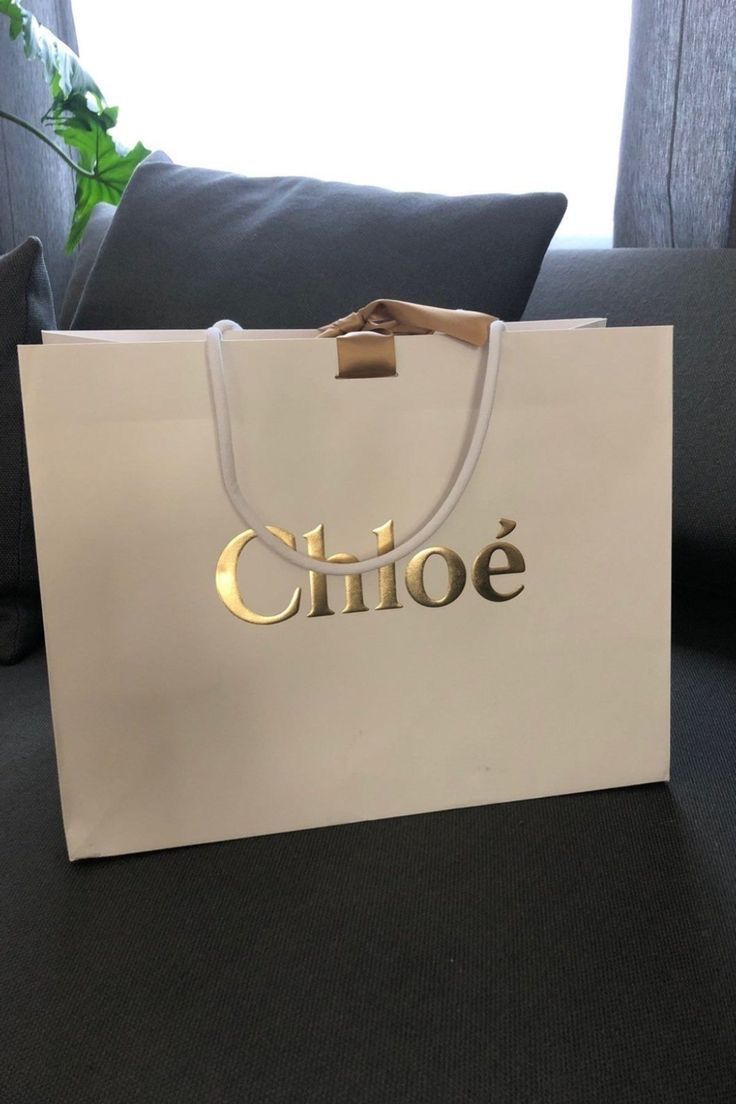 a white paper bag with the word'chloe'on it sitting on a couch