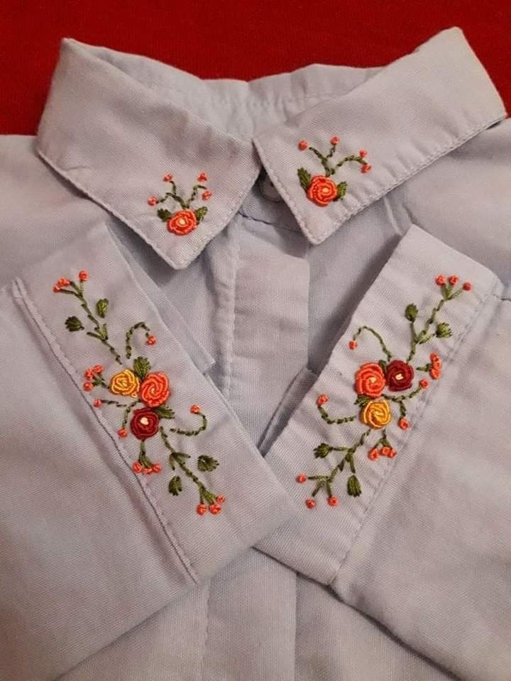 an embroidered shirt with flowers on the front and back, sitting on a red surface