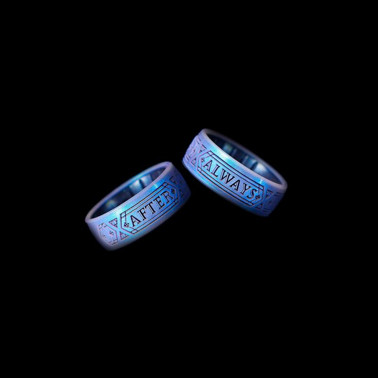 two wedding bands with the words atlanta engraved on them, against a black background that is lit up