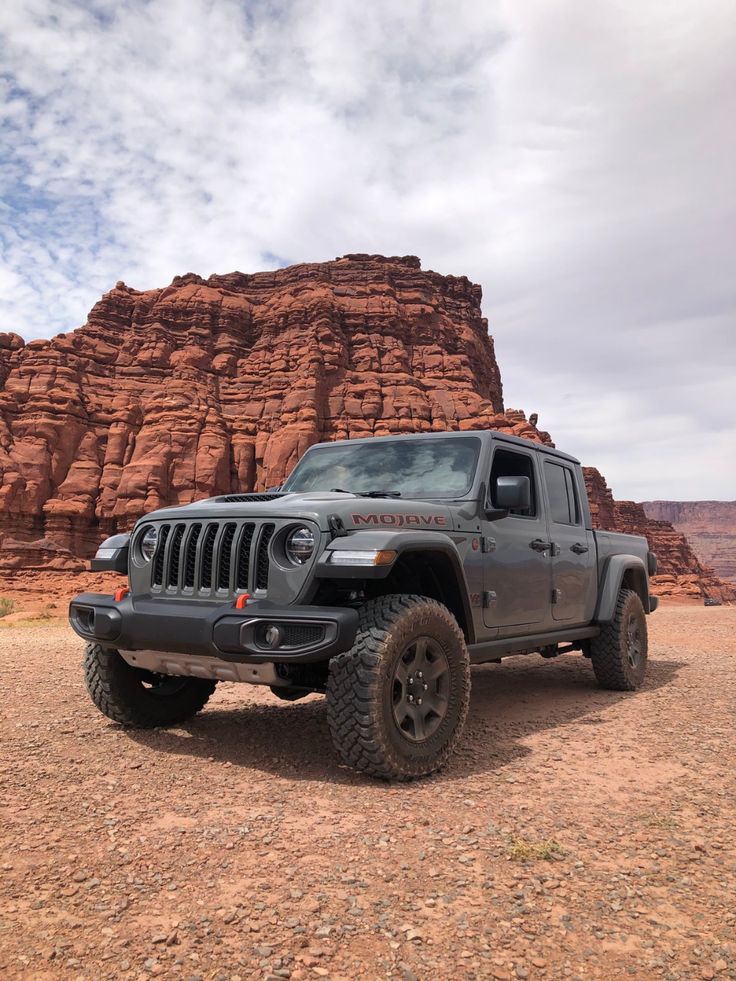 a jeep parked in front of a large rock formation