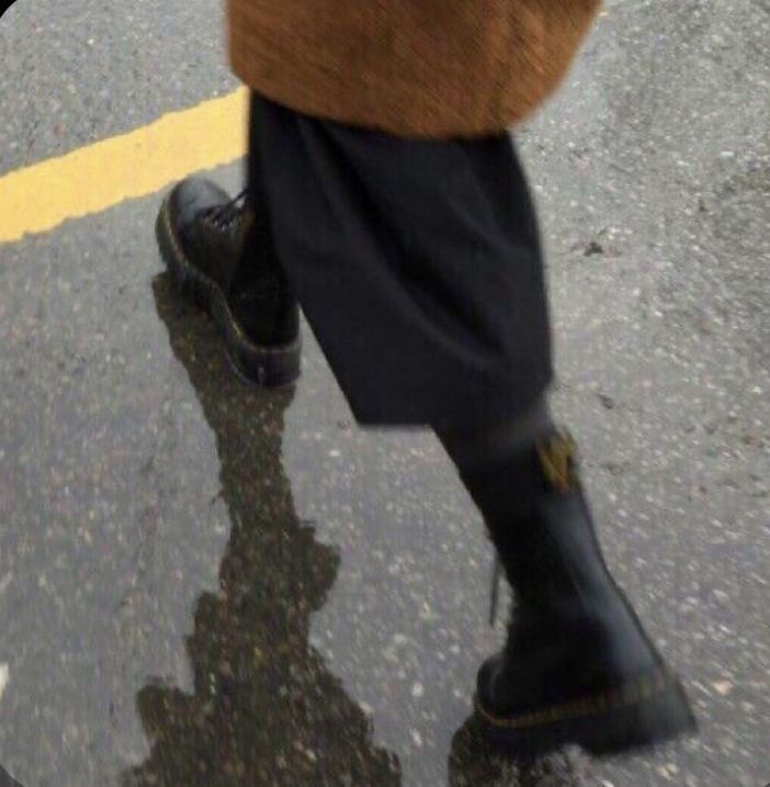 a person walking down the street in rain boots