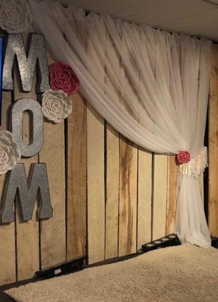 a room decorated with white curtains and flowers