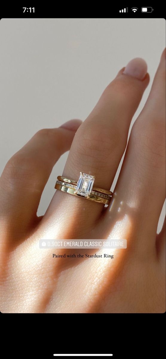 a woman's hand with a diamond ring on top of her finger and the other hand holding it