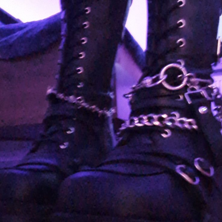 a pair of black boots with chains on them