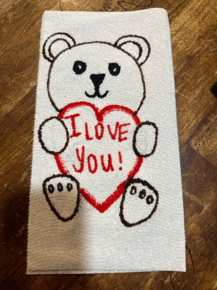 a white towel with a bear holding a heart on it that says i love you