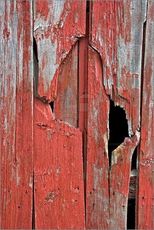 an old red wooden door with holes in the paint and peeling paint on it's sides