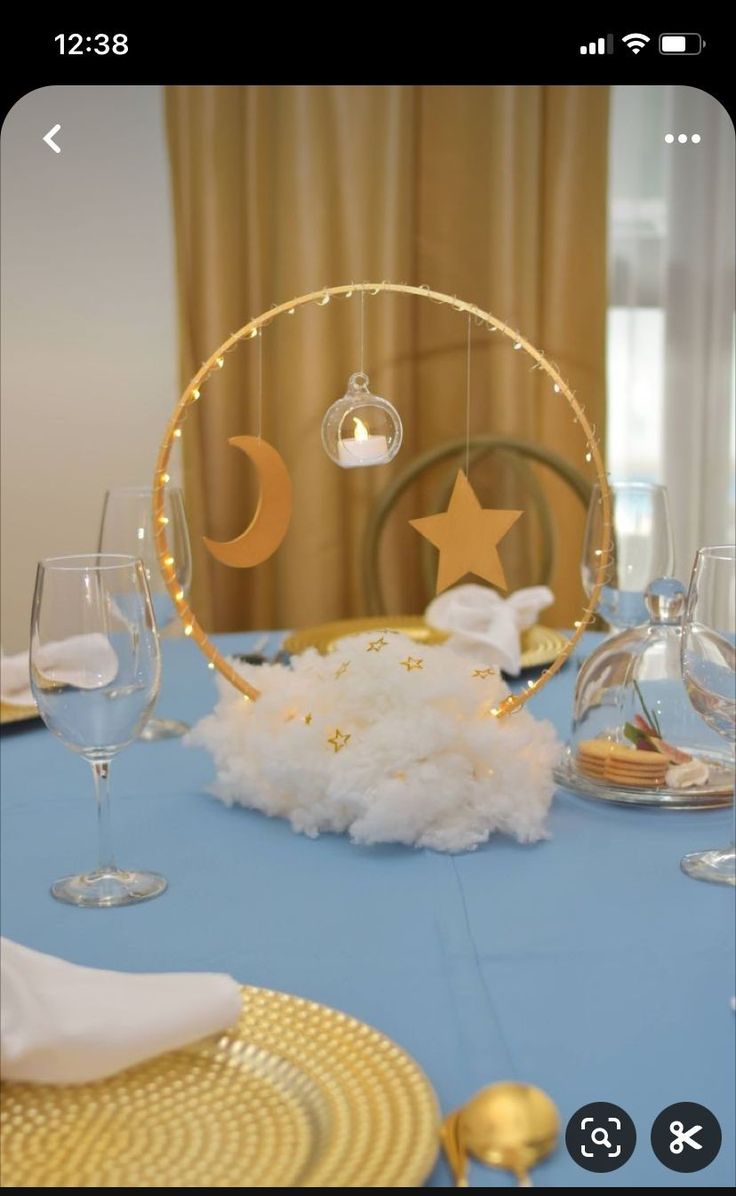 the table is set for a baby's first birthday with stars and moon decorations