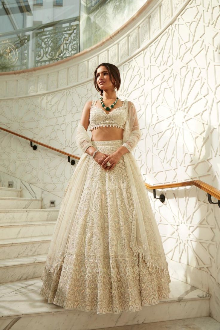 a woman in a white dress standing on some stairs