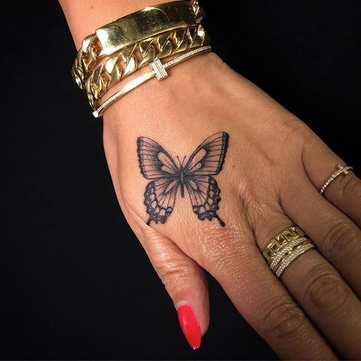 a woman's hand with a butterfly tattoo on it